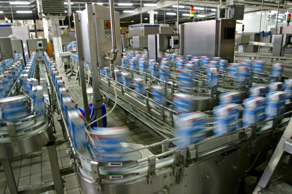 A factory with many cans of milk on the conveyer belt.