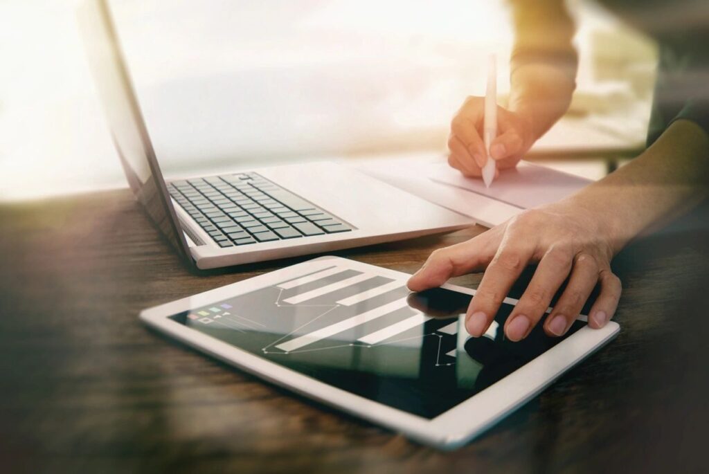 Person working with laptop and tablet.