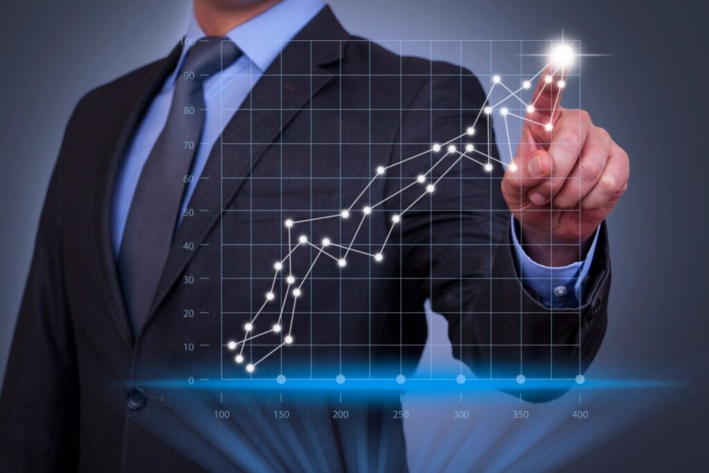 Businessman pointing at upward trending graph.