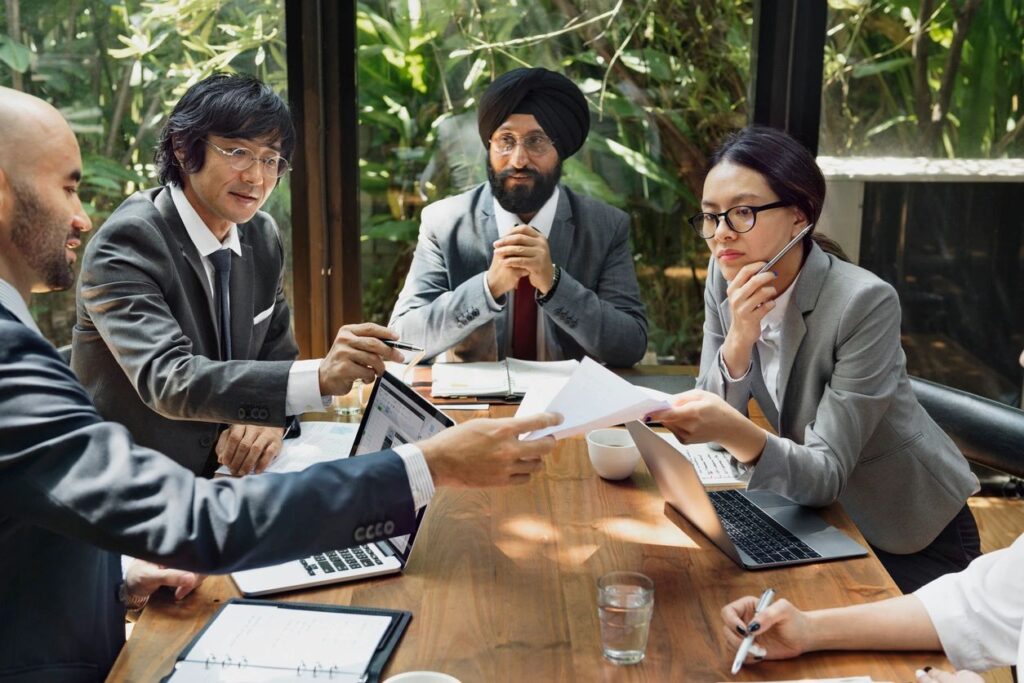 Business team reviewing documents around conference table