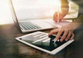 Person working with laptop and tablet.