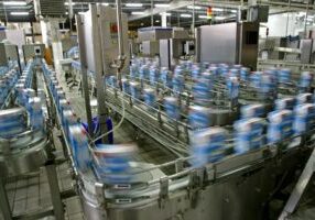 A factory with many cans of milk on the conveyer belt.