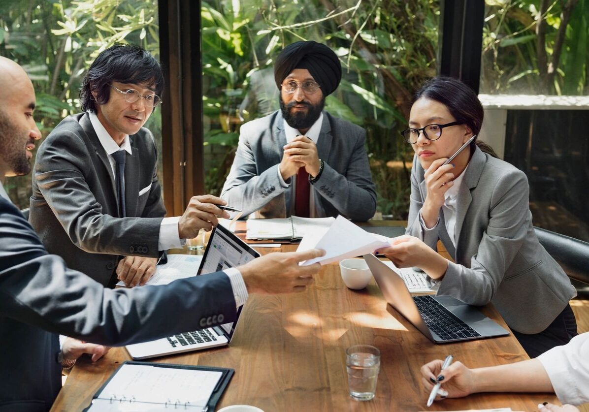 Business team reviewing documents around conference table